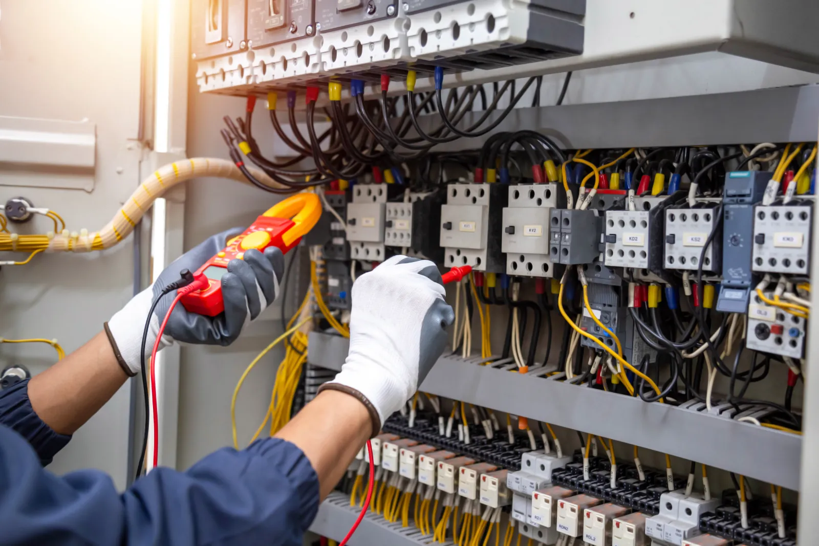 Elektriker prüft einen Schaltschrank mit einem Messgerät